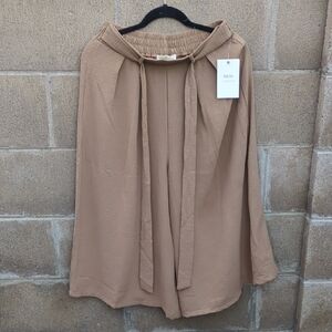 beige wide-leg pants with a matching sash tie. 